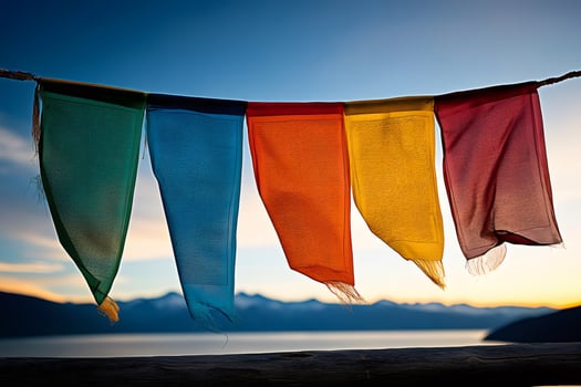 Colorful prayer flags waving in the wind at sunset over a lake photo