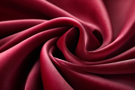 Burgundy silk fabric forming an elegant swirl pattern photo