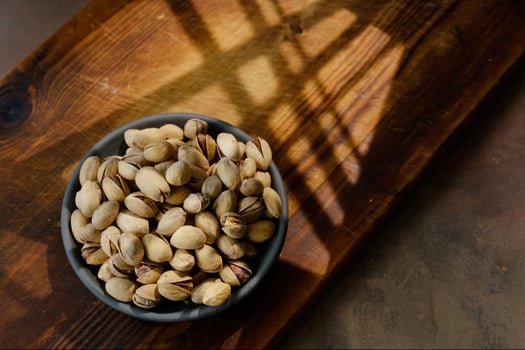 Roasted pistachios nuts in bowl on wooden table. Nuts background. photo