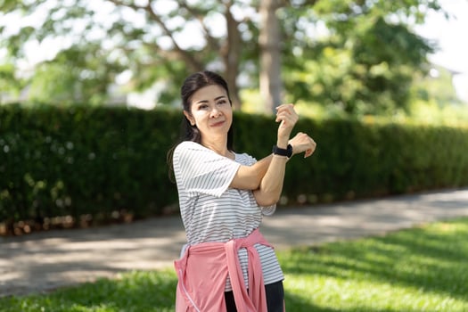 Wellness through yoga stretching for elderly woman in green park photo