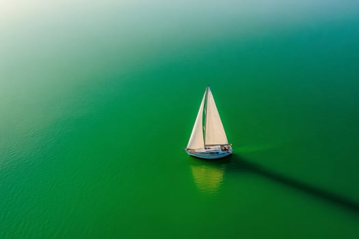 Sailboat sailing on calm green water during golden hour photo