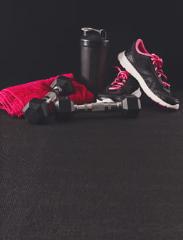 Female sport clothing and equipment copy space. Sneakers, dumbbells, towel and water bottle. Active lifestyle, body care concept photo