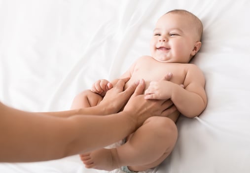 Colics prevention. Masseur massaging tummy of newborn baby, healthcare and babycare, copy space photo