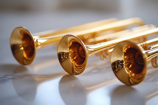 Three gold trumpets arranged on a reflective marble tabletop surface photo
