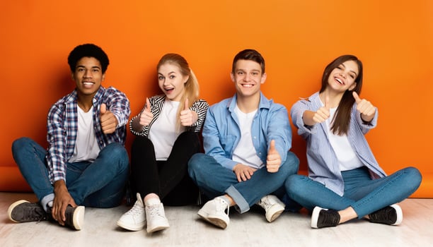 Education concept . Happy team of students showing thumbs up over orange background photo