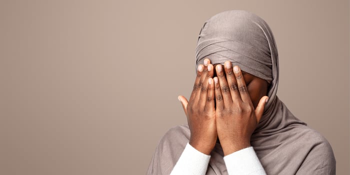Closeup Shot Of Black Muslim Woman In Hijab Covering Face With Hands, Crying African Islamic Lady Suffering Religious Discrimination, Rasicm Or Islamophobia, Standing Over Light Background, Copy Space photo
