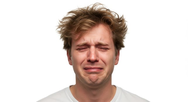 Crying Young Caucasian Man with Messy Hair Showing Emotional Distress on White Background photo