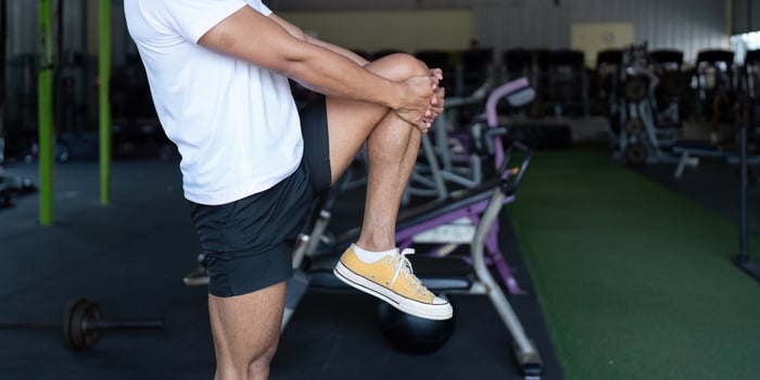 Wellness and Strength. Young man performing a knee lift exercise in a gym. photo