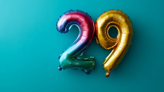 Vibrant rainbow foil balloon displaying the number twenty-nine on a blue background for a festive celebration photo
