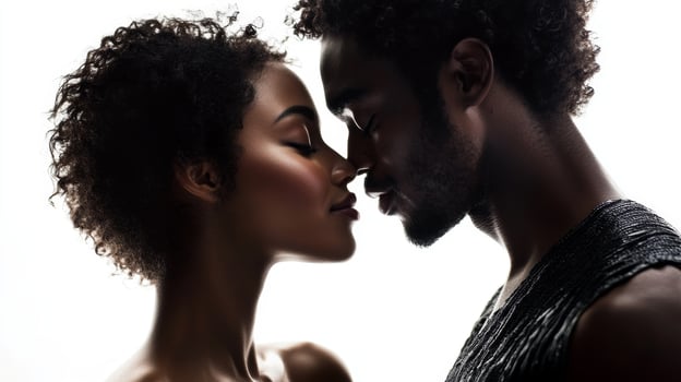 A beautiful black couple shares a romantic kiss while gazing into each other's eyes against a white background photo