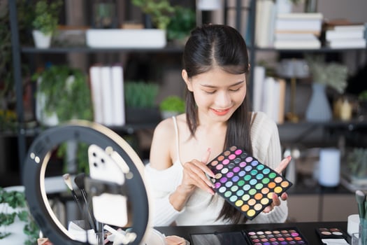 a woman is holding a palette of makeup products photo