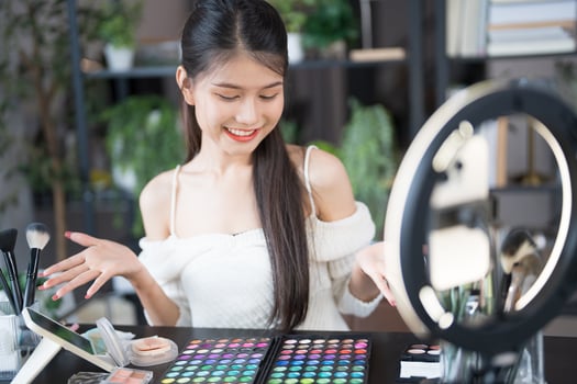 a woman is smiling while holding a makeup palette photo