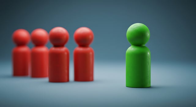 Isolated Green Figure Among Red Figures on a Neutral Background photo