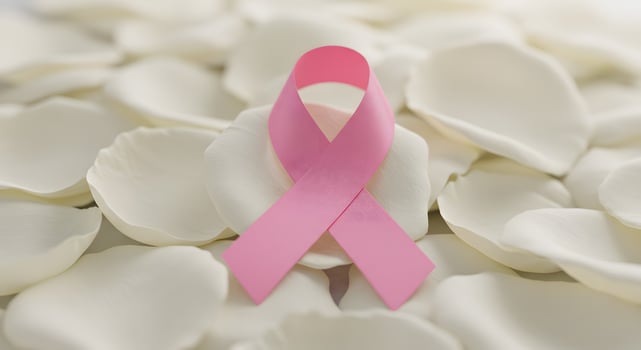 Pink ribbon on white rose petals photo