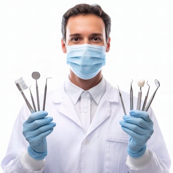A man in a white coat and mask holding dental tools photo