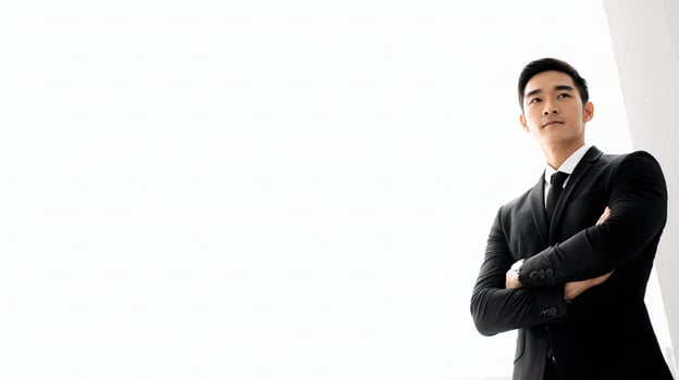 Asian man in suit standing with arms crossed photo