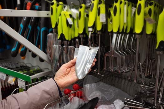 Person examining gardening tools in a hardware store. Handles product. photo
