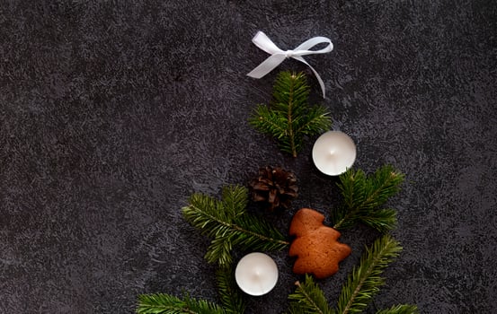 photograph of a Christmas setting with heart-shaped candy canes, gingerbread cookies, cinnamon sticks, pine sprigs, candles photo