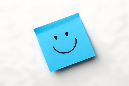 Blue Sticky Note with Smiley Face on Desk photo