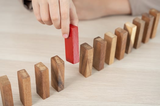 hand protect domino. Businessman hands stop dominoes falling in business crisis. business risk control and planning and strategies to run prevent insurance businesses. photo