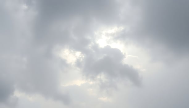 group of people standing on top of a beach under a cloudy sky photo