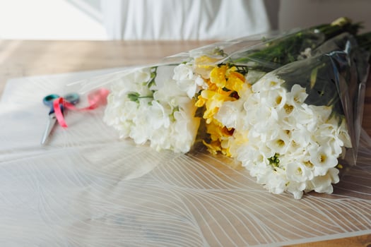 Florist preparing beautiful bouquets with colorful flowers in a bright workspace. photo