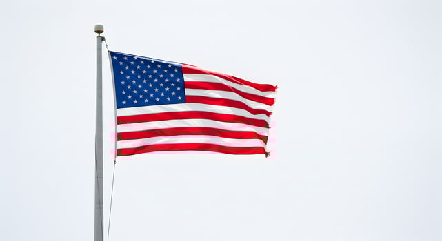 Waving Flag with Stars and Stripes Against Clear Sky photo