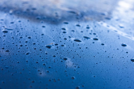 Water droplets accumulate on a blue surface after rainfall during early morning hours photo