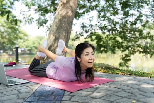 Wellness and Strength. A woman practicing bow pose outdoors. photo
