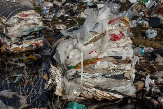 Piles of waste and plastic bags are found near a river, highlighting environmental neglect and the urgency for better waste management solutions photo