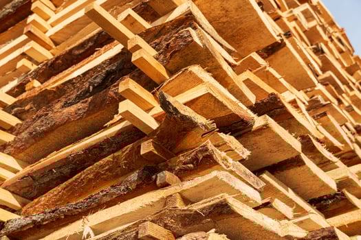 Wooden planks are neatly stacked and drying under the bright sunlight at a lumber yard in the afternoon, showcasing their natural texture photo