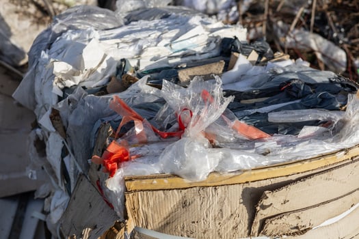 Piles of plastic, cardboard, and mixed debris are stacked high in a junkyard, showcasing the effects of urban waste accumulation photo