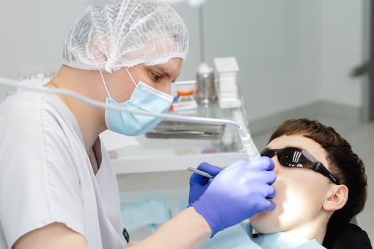 Dentist performing dental checkup on young patient. photo