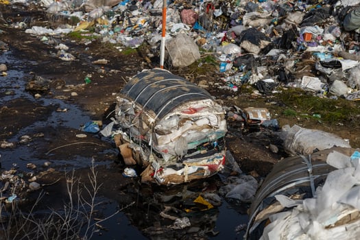 Piles of trash and debris clutter a roadside in a neglected area, highlighting environmental concerns and poor waste management practices photo