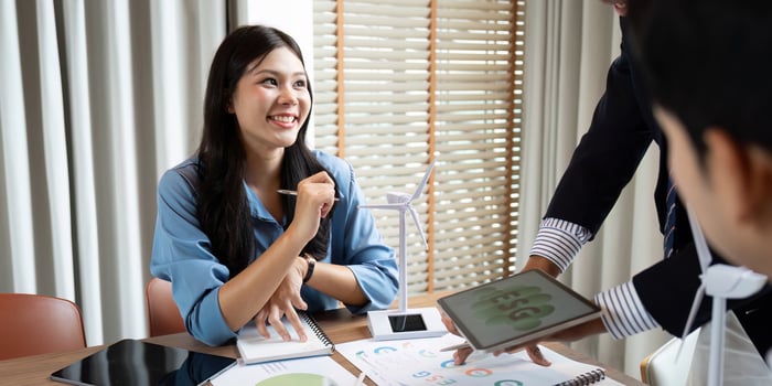 Sustainability and ESG. Smiling professional discussing ESG strategies in a collaborative office environment. photo