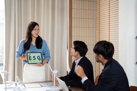 ESG Presentation. Business professional presenting sustainability initiatives to engaged colleagues in a modern office. photo