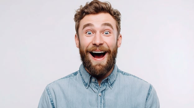 A man with a beard and a blue shirt is making a surprised face photo