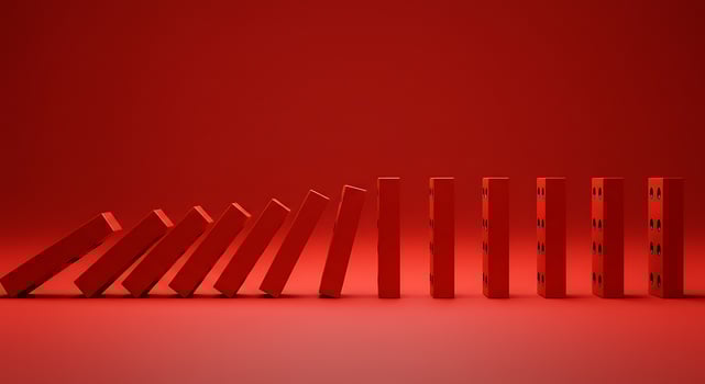Red dominoes falling in a chain reaction against a matching back photo