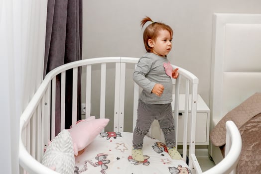 one year old baby girl in the bedroom in a crib photo