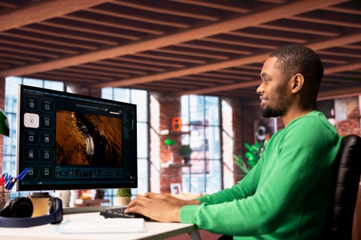 Smiling man using AI program turning text prompt into videos, pleased by results. Joyous african american person interacting with text to artificial intelligence generative model photo