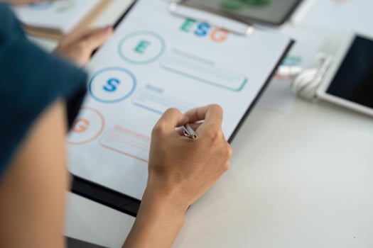 ESG Focus. Individual analyzing Environmental, Social, and Governance metrics on a clipboard. photo