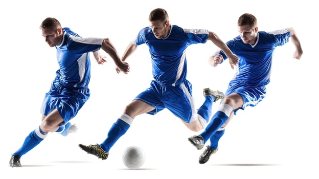 Four soccer players in blue uniforms are kicking a ball photo