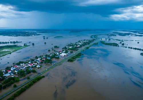 A flooded area with houses and a road photo