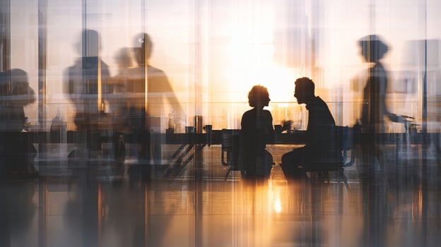 People sitting at a table in an office with the sun setting photo