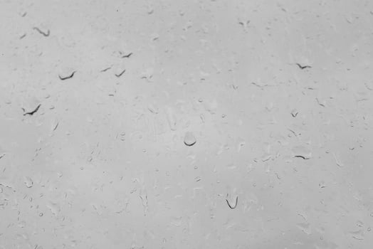 Rain drops on a window create a natural texture. Transparent liquid element for background or overlay effect concept on a gray surface. photo