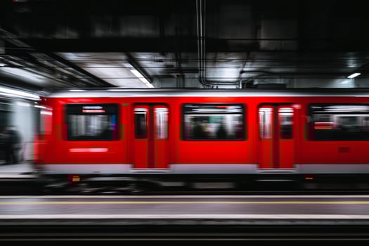 A red train moving through a subway station photo