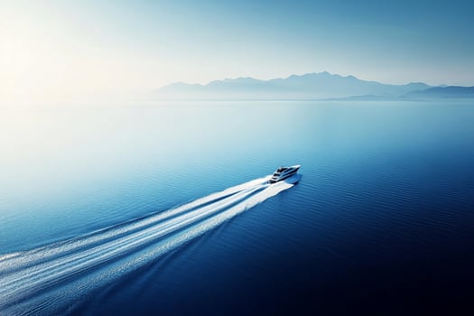 A boat traveling across the ocean with mountains in the background photo