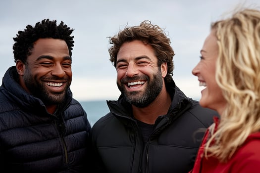 Three people laughing together on the beach photo