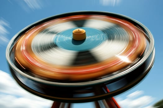 A spinning ferris wheel with a blue sky in the background photo