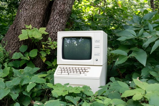 An old computer sitting in the middle of the woods photo